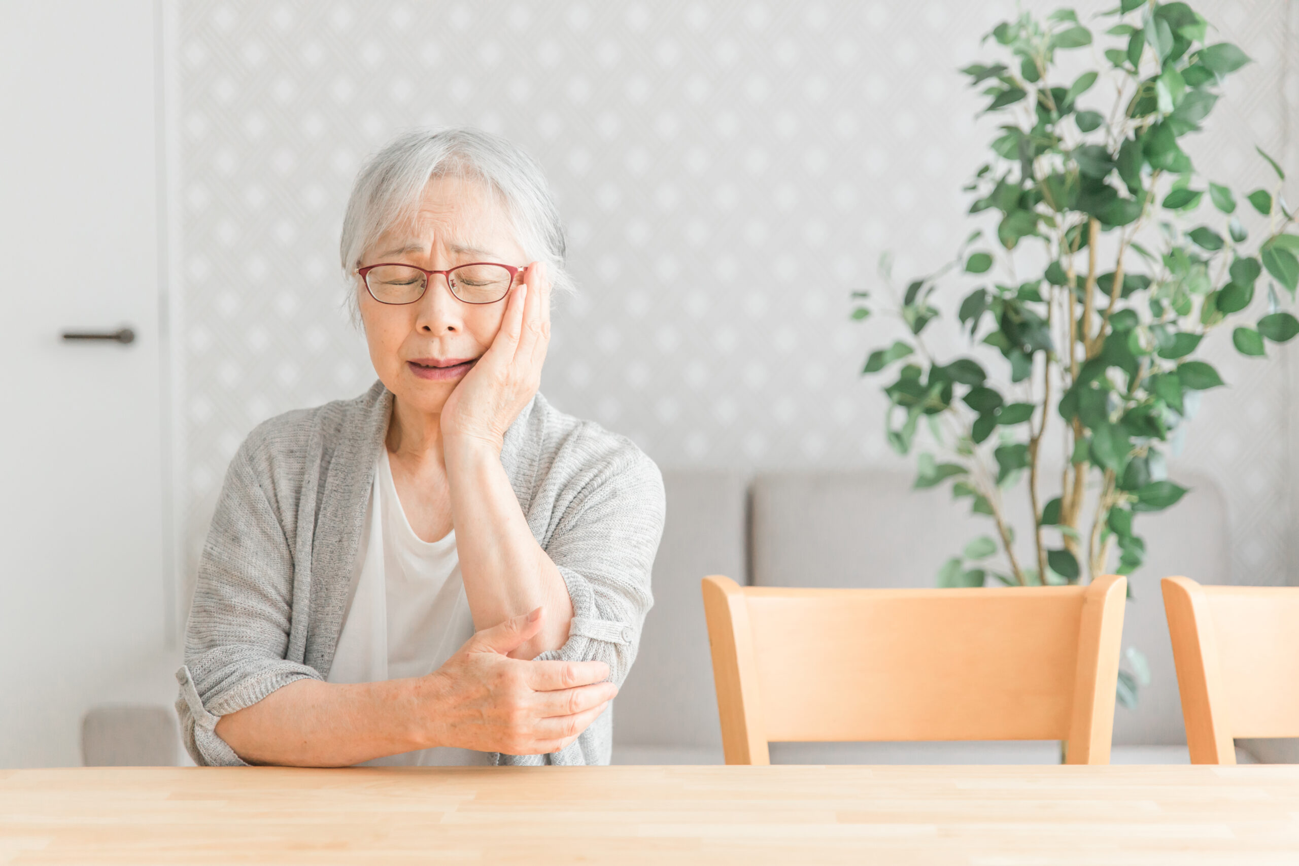 老人が頬も押さえて痛がっている様子